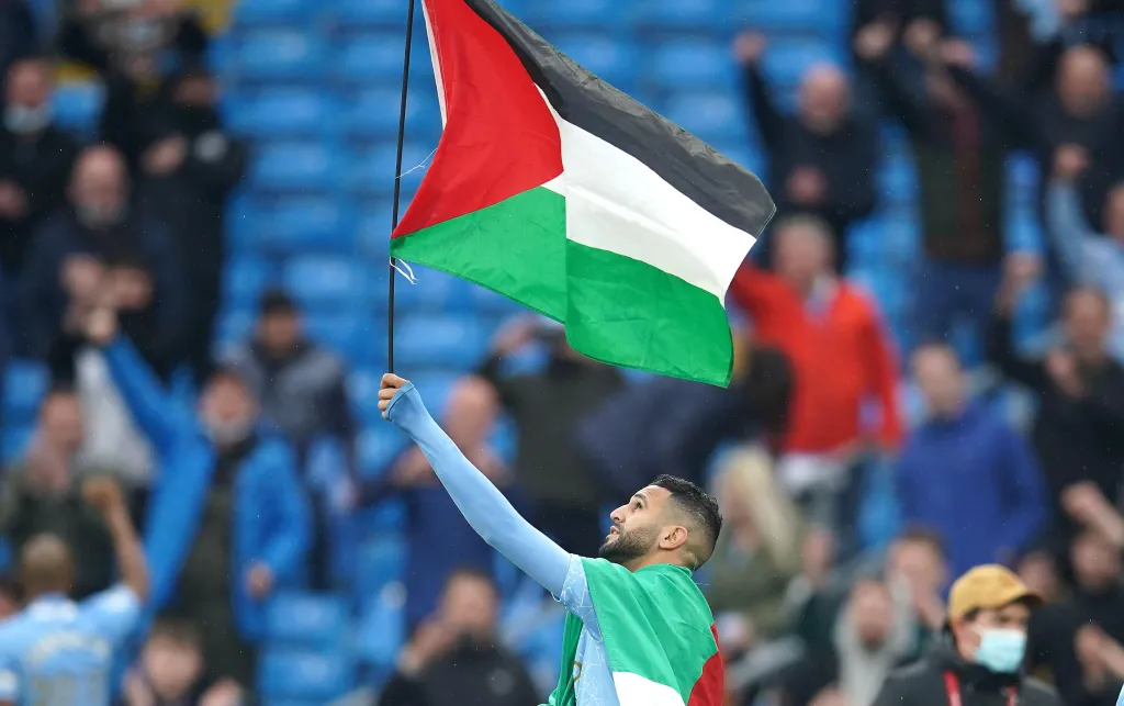 Manchester City's Riyad Mahrez with a Palestine flag