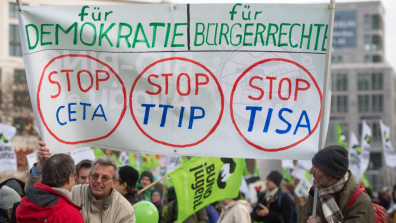 Protestors hold a Stop CETA, Stop TTIP and Stop TISA banner.