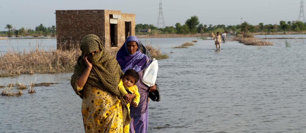 A family crosses the flooded streets of Pakistan. Photo: ADB