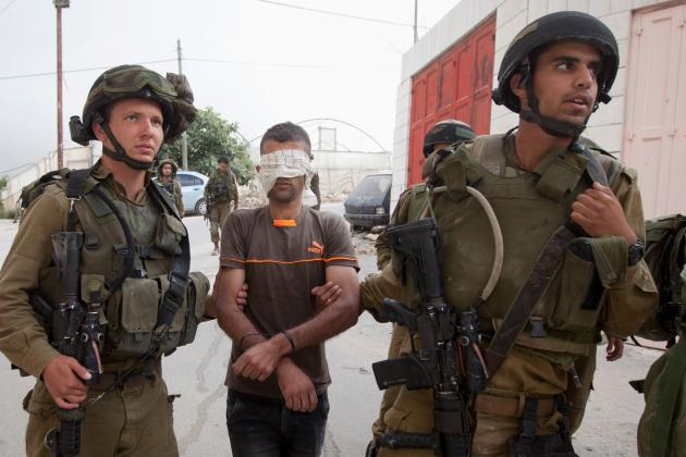 Israeli soldiers arrest a Palestinian man. Photo: Majdi Mohammed/ AP/ Shutterstock