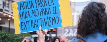 Women holding a protest sign against extractivism, Buenos Aires, August 2022