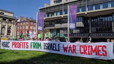 Campaigners protest at HSBC's 2018 AGM, holding a giant banner reading "HSBC profits from Israeli war crimes".