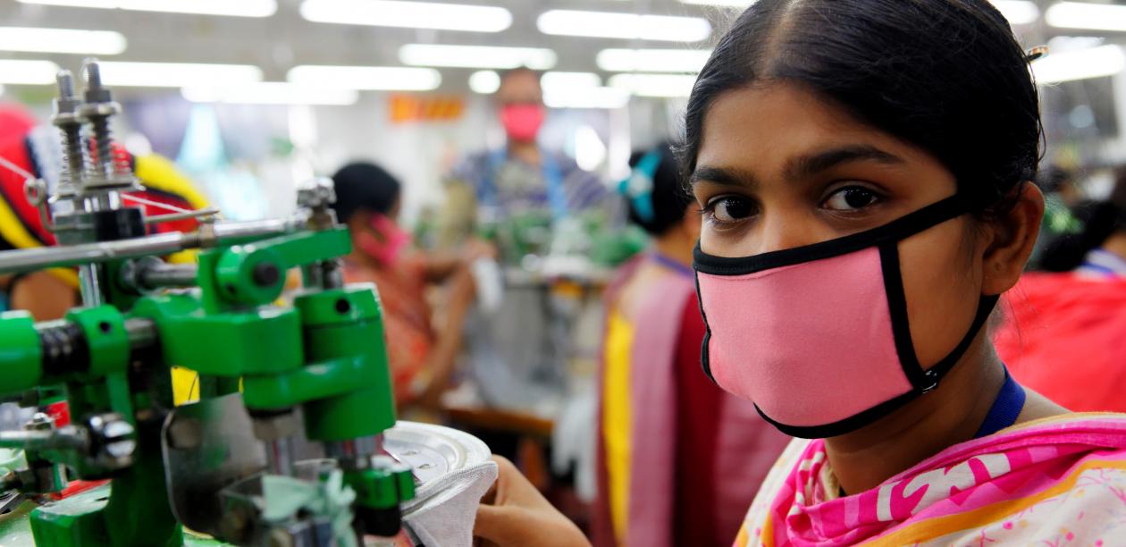 A Bangladeshi garment worker is seen wearing a face mask while producing clothing to be sold on major overseas markets. Photo: Marcel Crozet / ILO